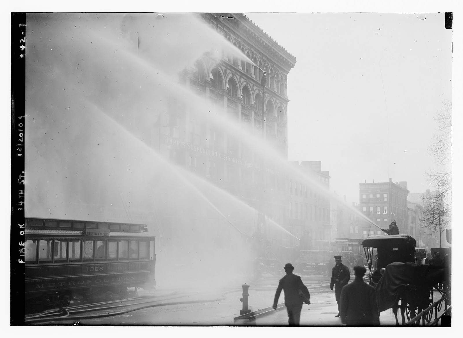Firemen spraying burning building on 14th St., trolley in foreground, New York, 12/20/09. — historic photograph
