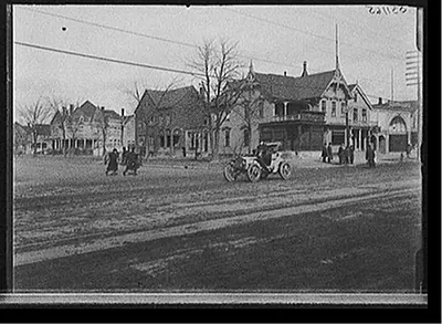 [Street with automobile and Moesta's store]