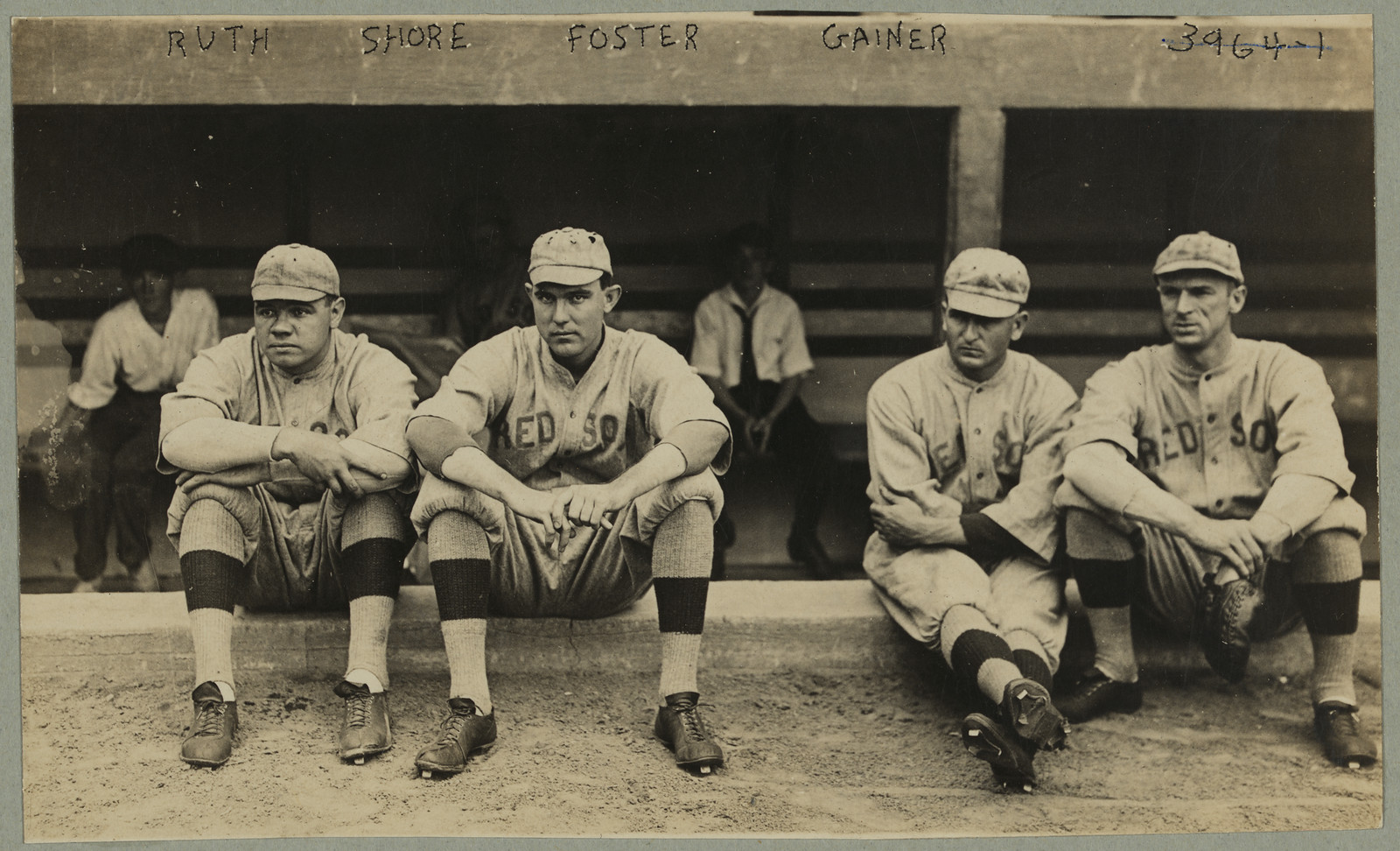 Four Red Sox players seated on dugout bench, names written above — historic image