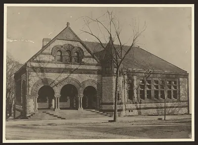 Stone Romanesque public library building with arched entrances