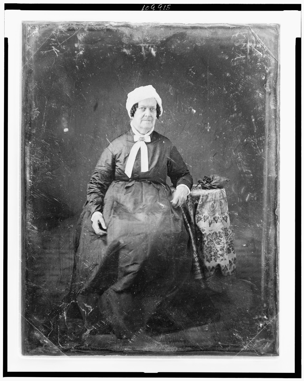 Seated elderly woman in white cap and dark dress, 1844 — historic photograph