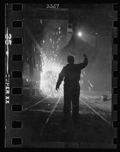 [Steel worker in mill as molten steel spills from vat, in Chicago, Illinois]