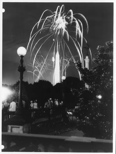 [Fireworks over the Washington Monument, with group of people on bridge in foreground]