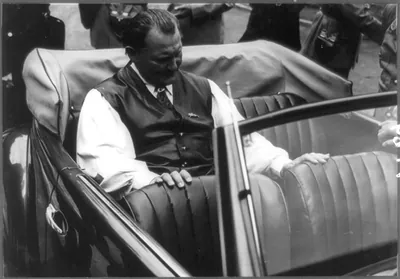 [Hermann Goering sitting in back seat of Volkswagen convertible given as a gift to Goering]