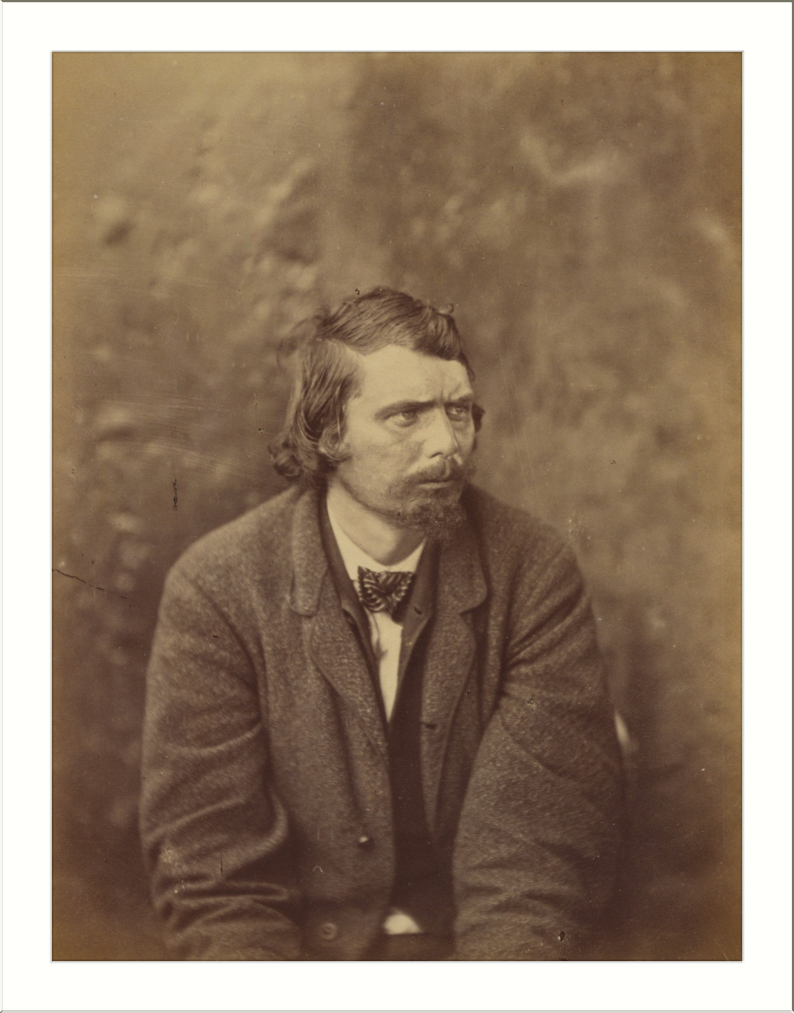 Sepia portrait of a bearded man in a coat — historic image