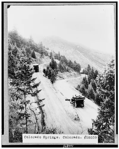 [Colorado Springs, Colorado. Two automobiles going down mountain road, with horseshoe turn in foreground] / Wiswall(?).