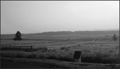 Rolling battlefield fields with split-rail and white fences