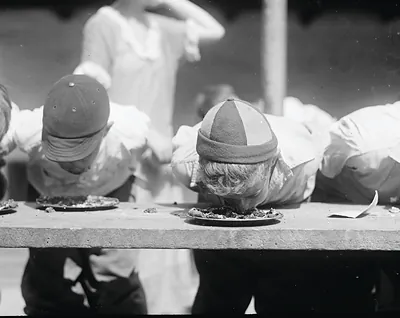 Boys with faces in pies at a pie-eating contest