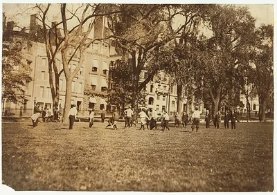 Boys playing football on a city park lawn