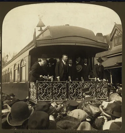 Man speaking from a train platform to a crowd