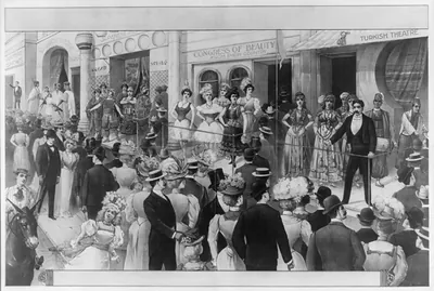 [Crowds at a circus sideshow viewing women and some men dressed in costumes of foreign lands]