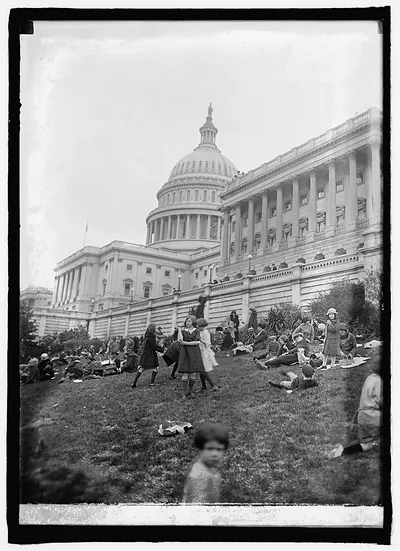 Children on Capitol lawn with dome, black and white photograph