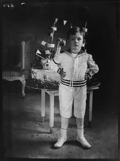 Vinson Walsh McLean with birthday cake [in shape of battleship] from Admiral Dewey