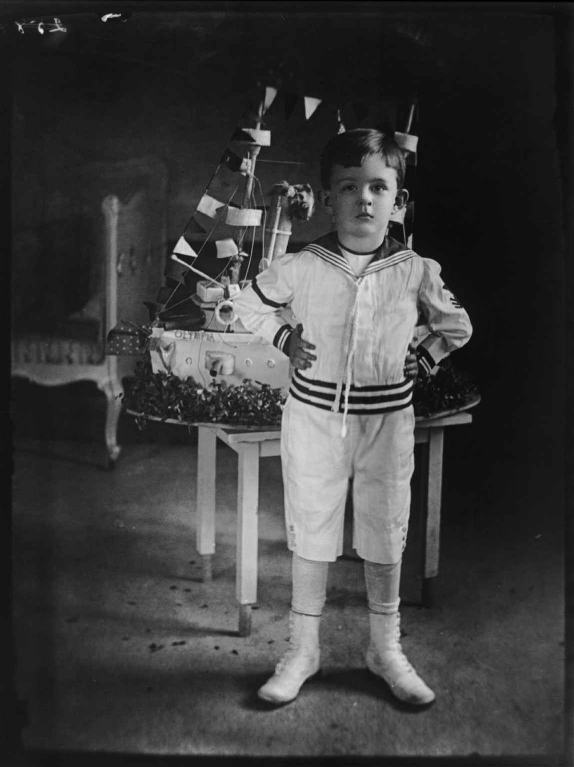 Vinson Walsh McLean with birthday cake [in shape of battleship] from Admiral Dewey, 1898 — historic photograph