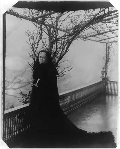 Gertrude McCurdy Hubbard, standing on the second-story porch at Twin Oaks" D.C. home of the Gardiner Greene Hubbard family"