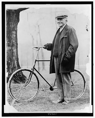 [John D. Rockefeller, full-length portrait, standing with a bicycle]
