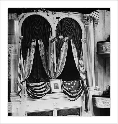 Draped flags and curtains framing a framed portrait in an arched alcove