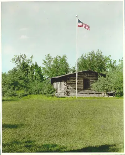 Log cabin with American flag on tall pole