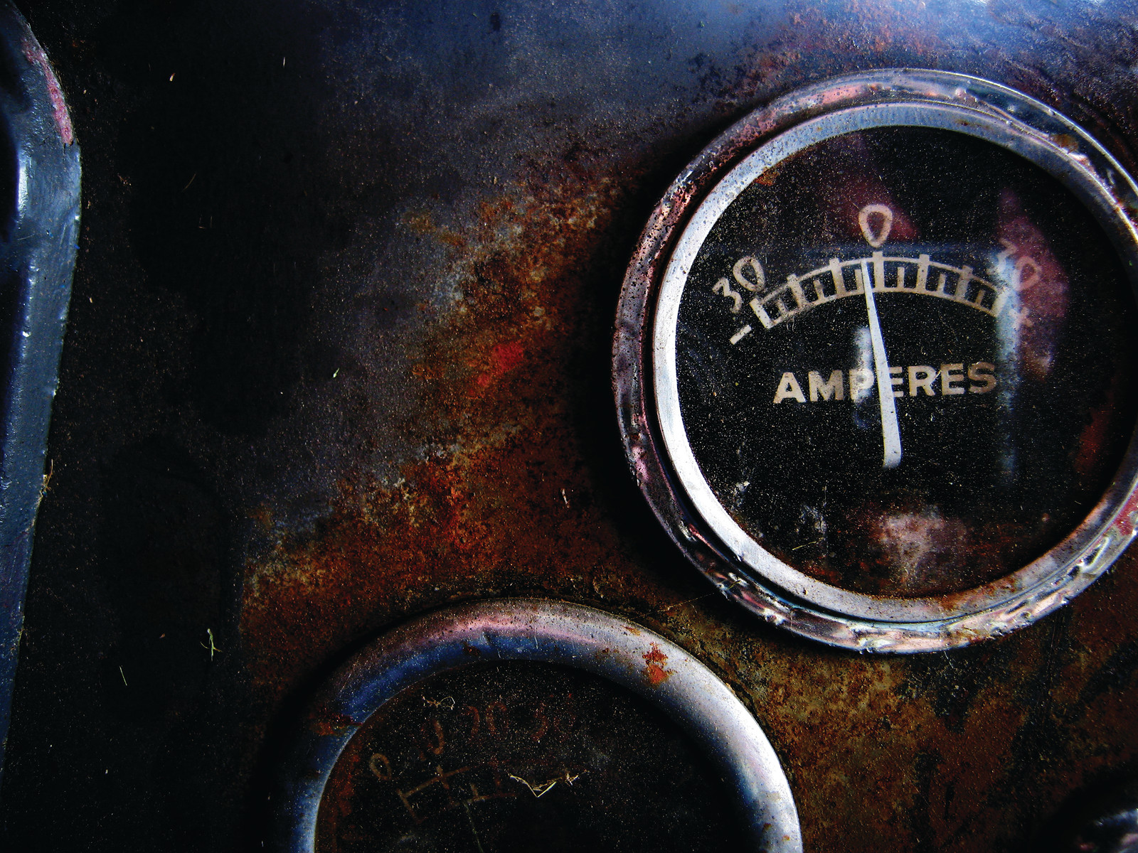 Close-up of rusted AMPERES gauge on a dashboard — historic image
