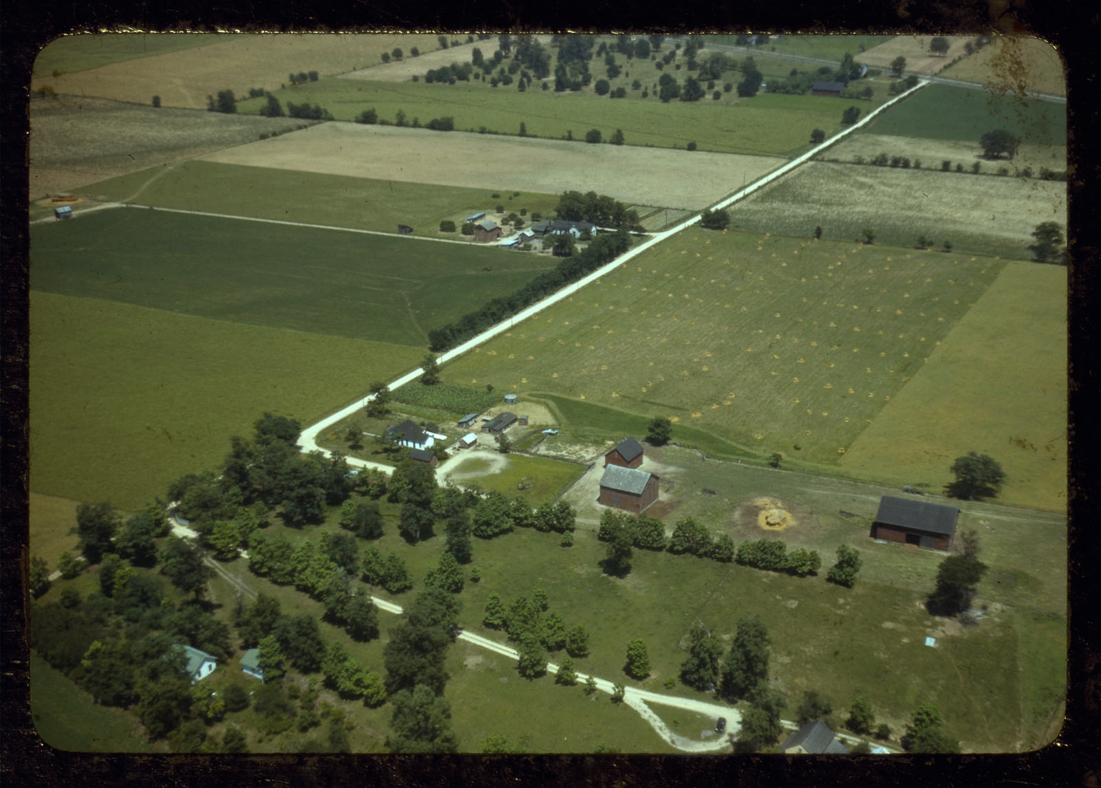 Aerial view of farmland with farm buildings and country roads — historic image