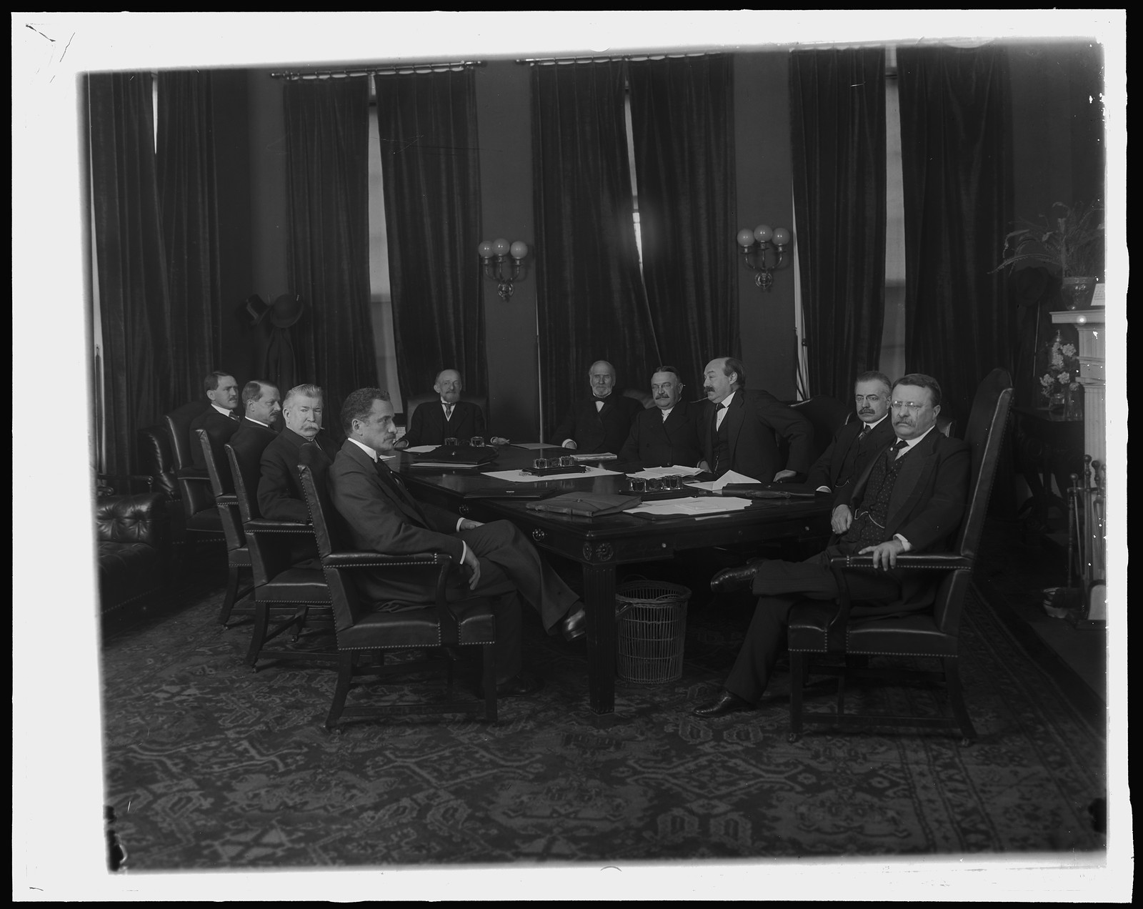 Seven men seated around a formal conference table — historic image