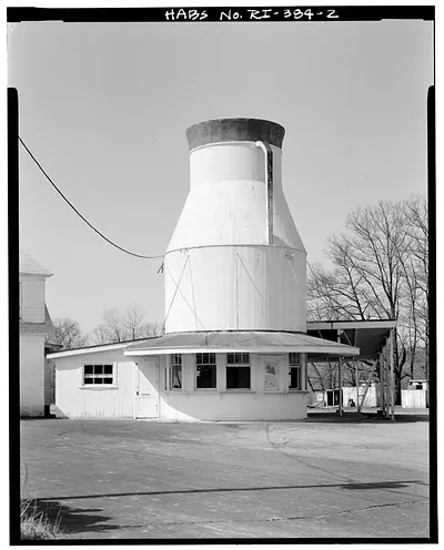 Milk can-shaped roadside building with attached white annex