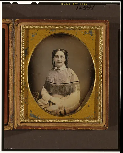 Seated woman in hand-colored daguerreotype, gilt mat and case