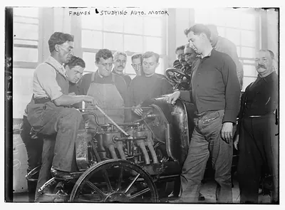 Firemen studying auto motor
