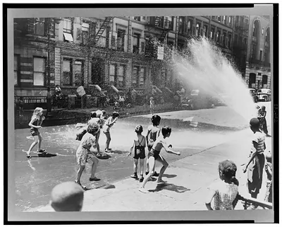 New York, New York. Children escape the heat of the East Side by using fire hydrant as a shower bath