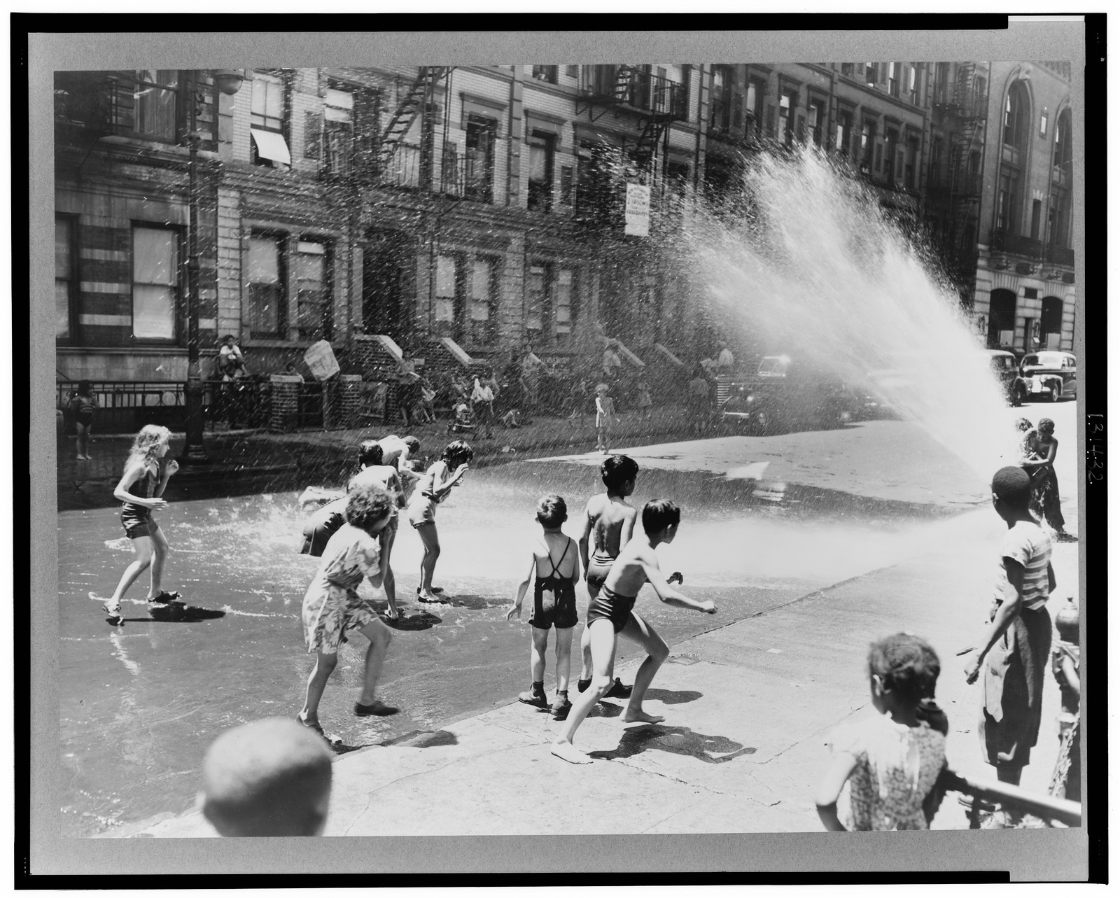 New York, New York. Children escape the heat of the East Side by using fire hydrant as a shower bath, 1943 June. — historic photograph