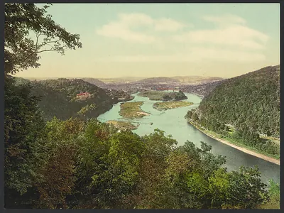 River winding through wooded hills with small islands