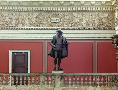 Bronze statue of Shakespeare beneath carved frieze inscribed SHAKESPEARE