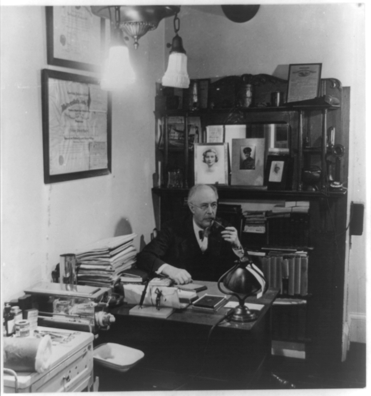 [Dr. Brooks, Croton, N.Y.: seated at desk in his office smoking pipe], 1944 — historic photograph