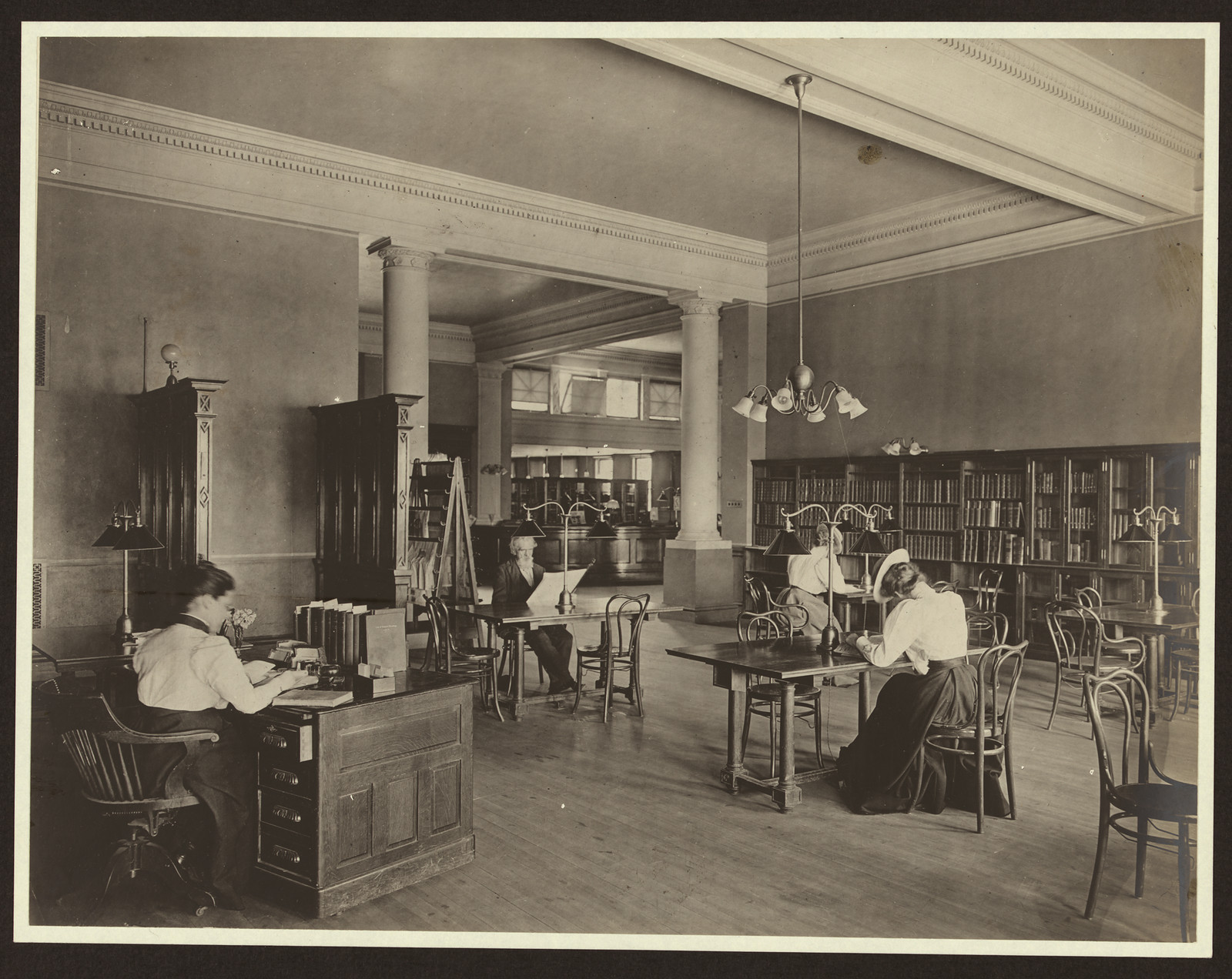 Adult reading room in a library with long wooden tables — historic image