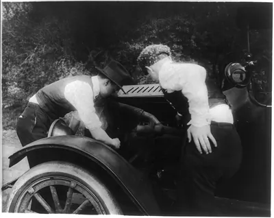 Men looking under hood of auto
