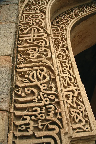 Carved Arabic inscription on a stone arch, Delhi mosque ruins