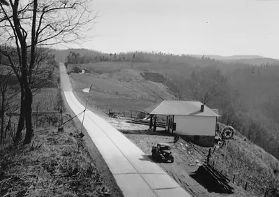 Concrete mountain road with roadside station and parked car