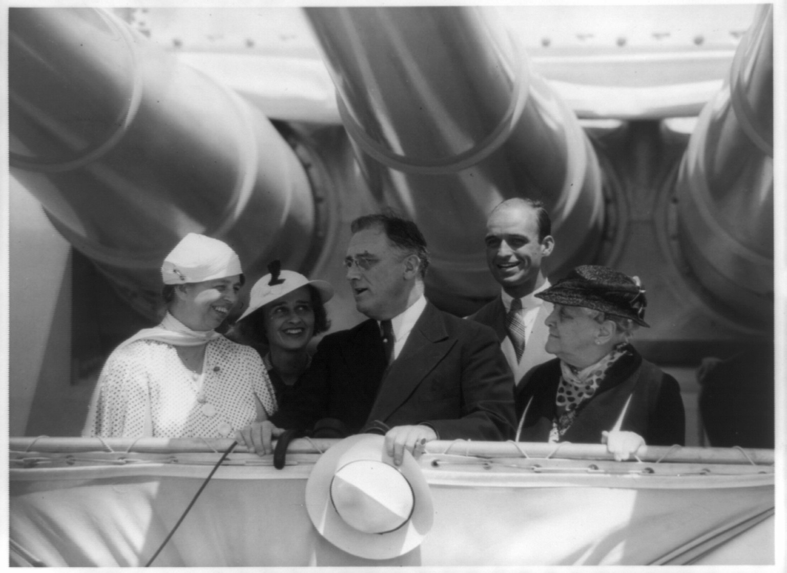 [Eleanor Roosevelt, Mrs. James (Betsy Cushing) Roosevelt, Franklin D. Roosevelt, James Roosevelt, and Franklin Roosevelt's mother, Mrs. James Roosevelt, posed standing under big guns on battleship], [between 1940 and 1945] — historic photograph