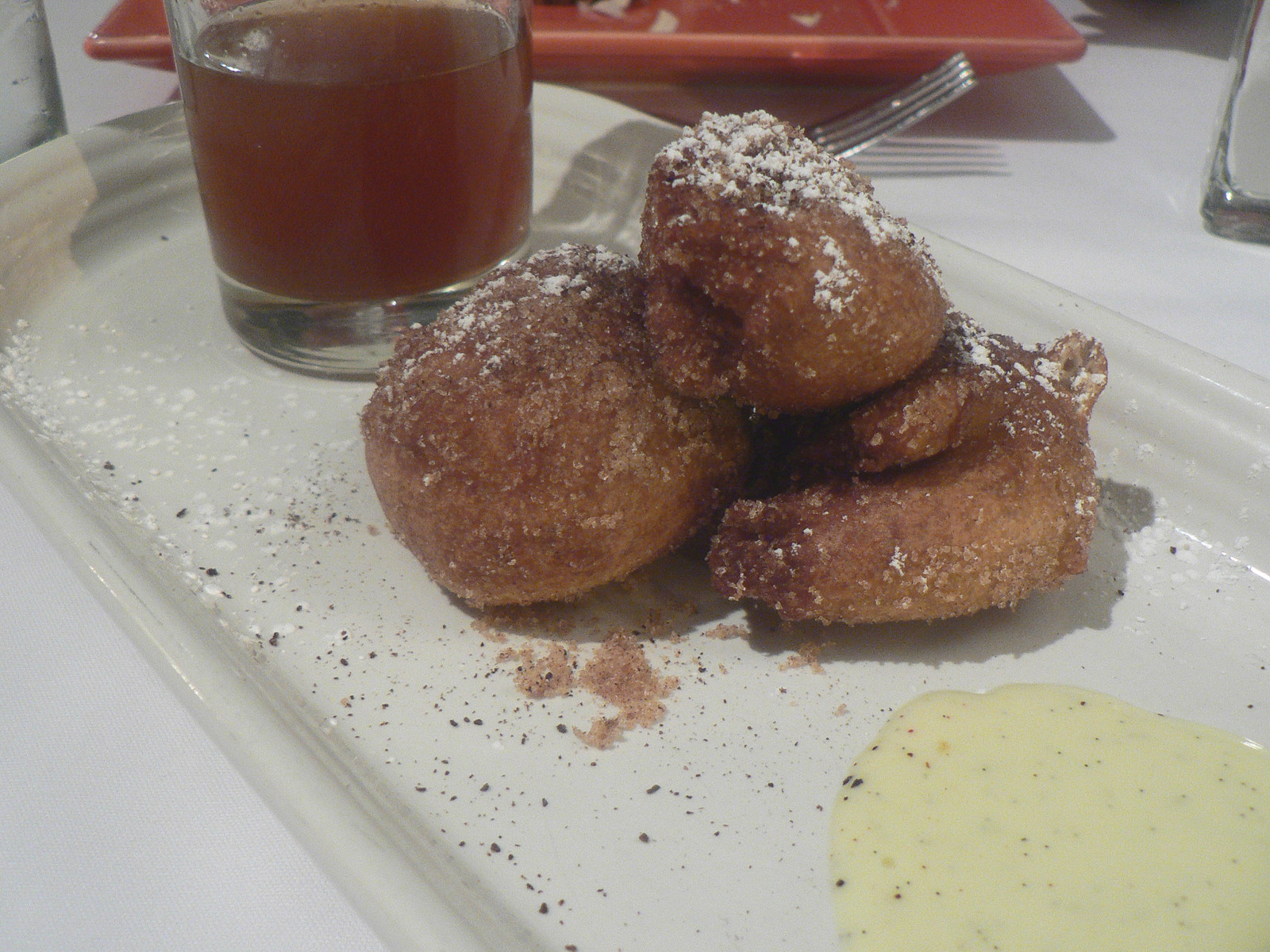 Fried dough balls dusted with sugar on a plate — historic image