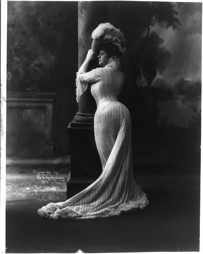 [Bianca Lyons, full length, standing, facing left; leaning against pillar]