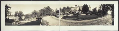 Panoramic photograph of hotel grounds with lawn and lake
