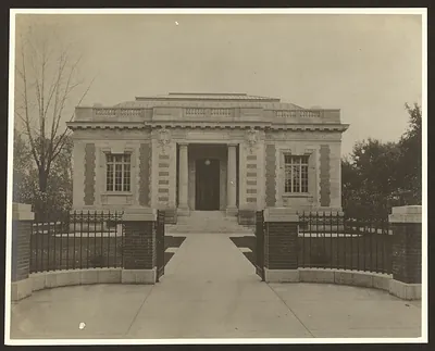 Neoclassical library building with iron gates and walkway