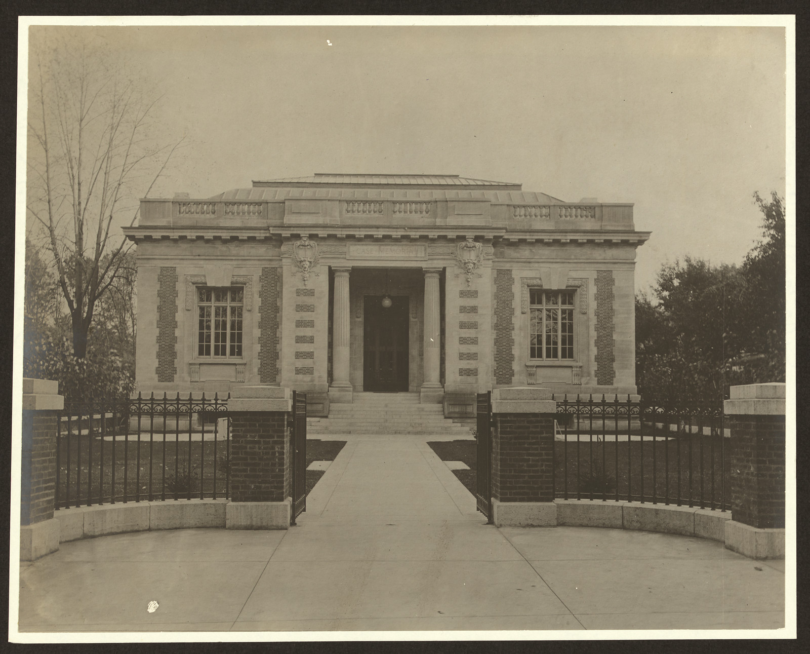 Neoclassical library building with iron gates and walkway — historic image
