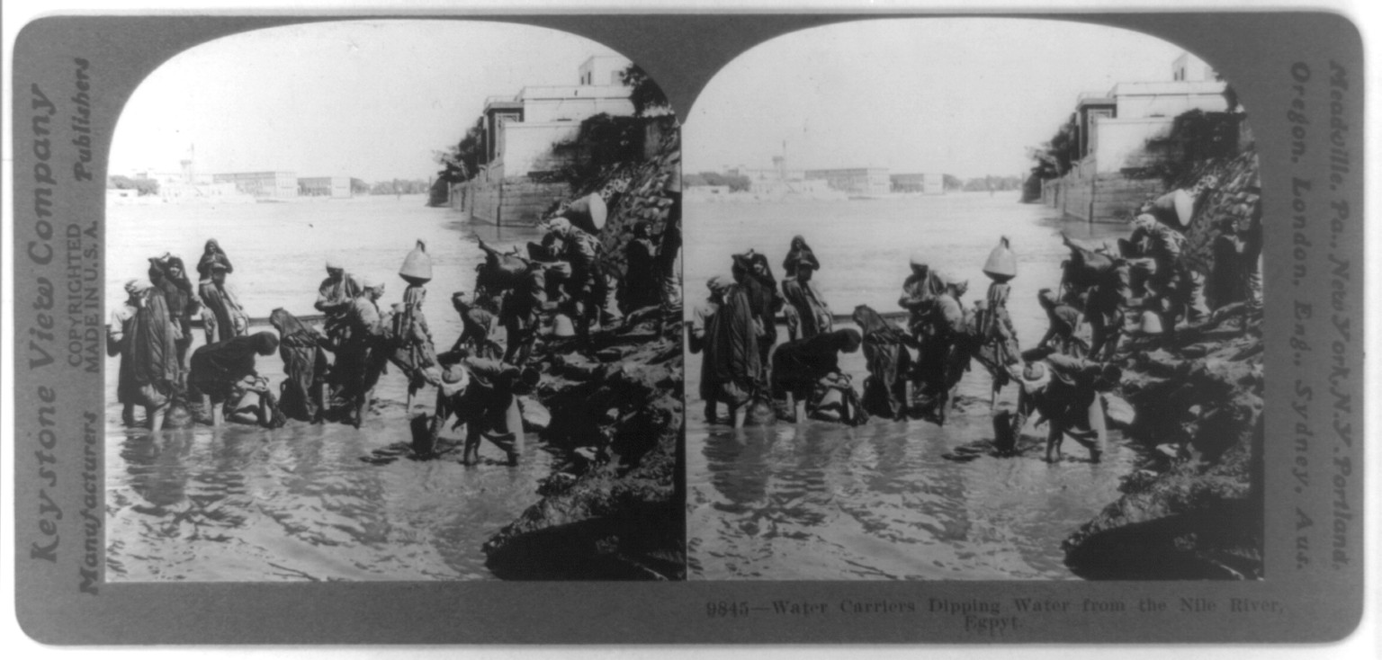 Water carriers dipping water form the Nile River, Egypt, c1919. — historic photograph