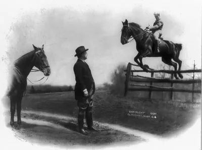 [Theodore Roosevelt watching his son Theodore Jr., who is riding on horse jumping over fence]