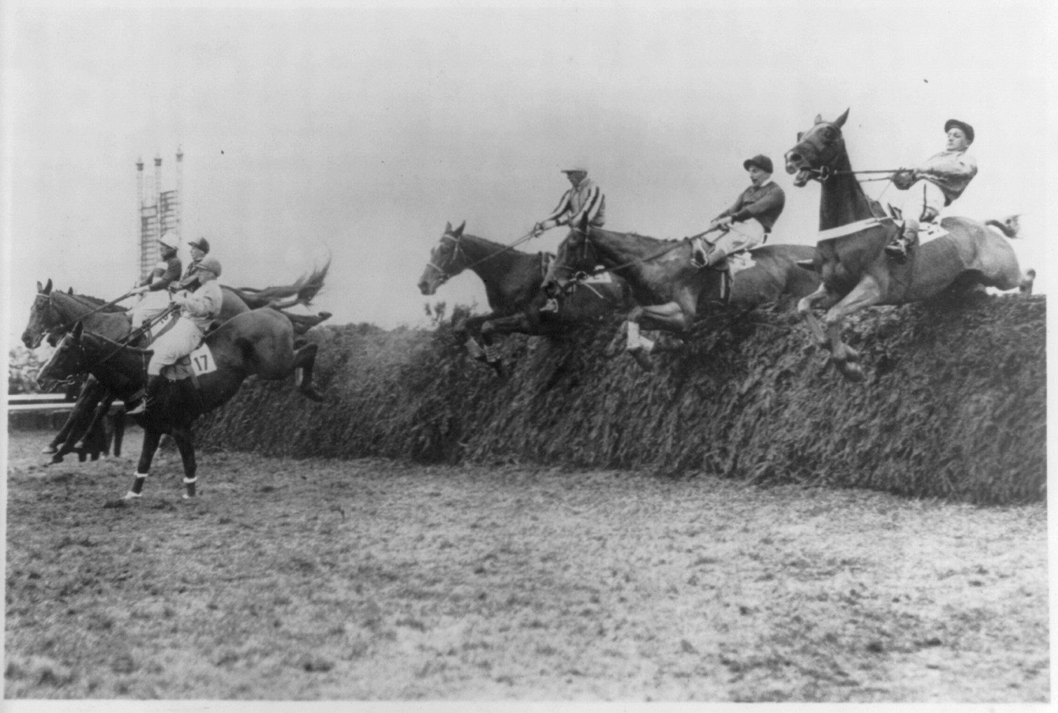 Six competitors clearing a jump in fine style at the Grand National Steeplechase, in which Shaun Goilin" won by a neck" — historic photograph