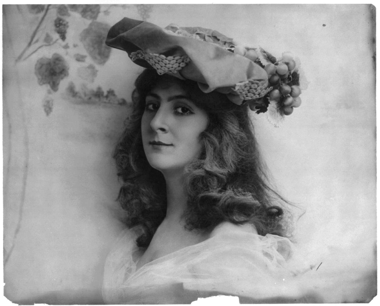 [Young woman modeling: Head and shoulders, grapes on hat], [no date recorded on caption card] — historic photograph