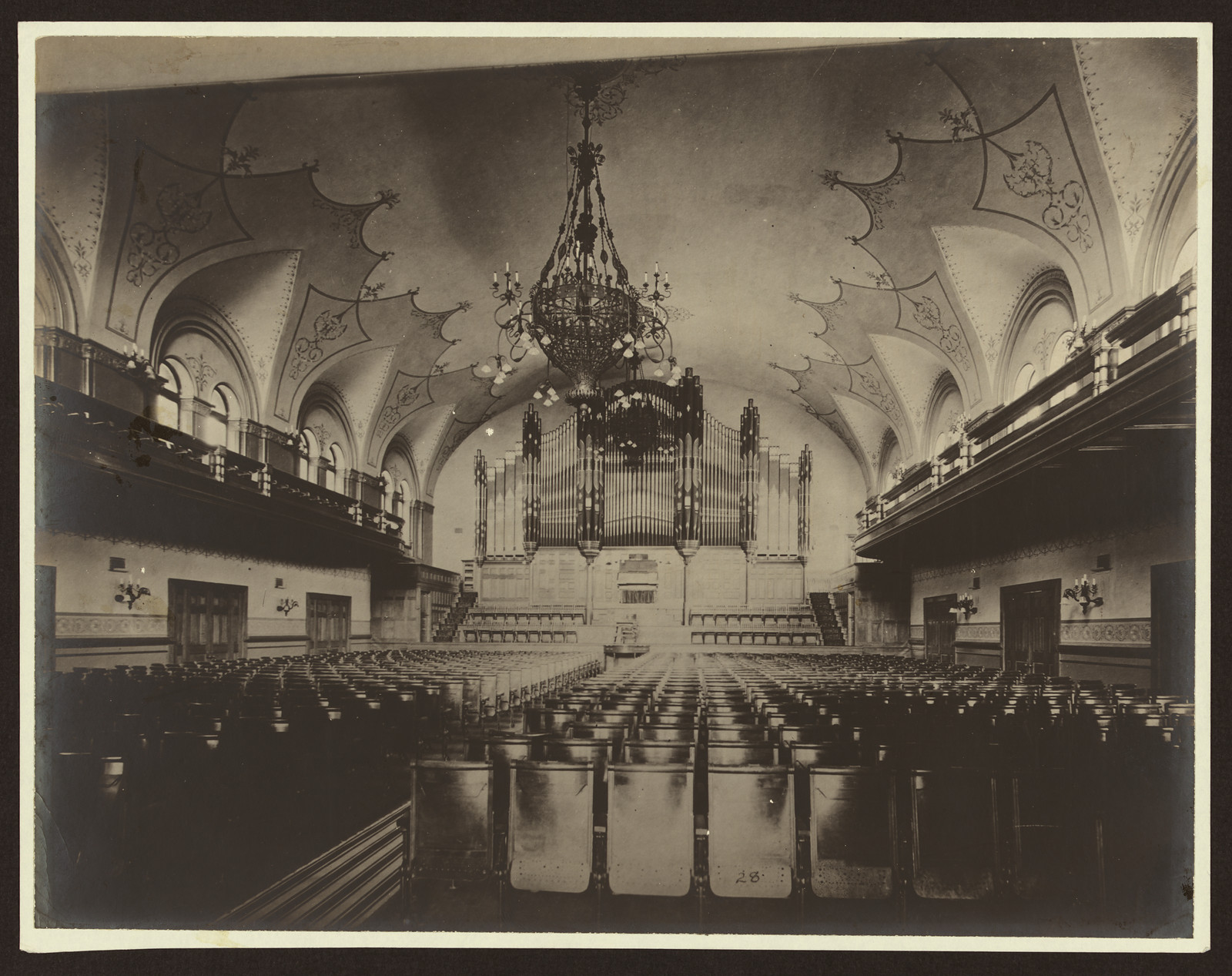 Concert hall interior with pipe organ and chandelier — historic image