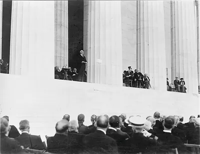Speaker addressing seated dignitaries and audience at Lincoln Memorial