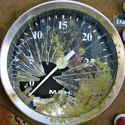Cracked speedometer with MPH scale and mossy glass